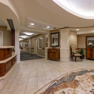 A spacious and elegantly designed hotel lobby with a reception area and comfortable seating.