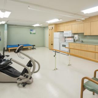 A spacious rehabilitation room featuring exercise equipment and a sterile environment for physical therapy.