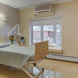 A clean and well-organized hospital room with a bed and window.