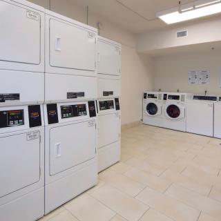 A clean and organized laundry room with multiple washers and dryers.