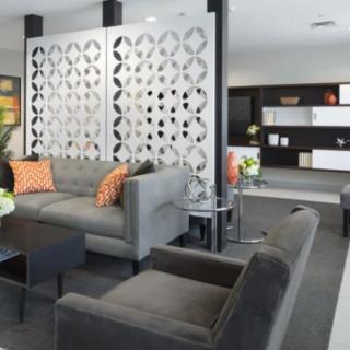 A modern living room with stylish furniture and decorative paneling.