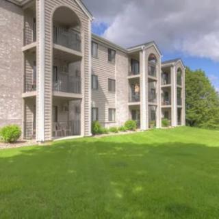 A modern apartment building set amidst lush green landscaping.