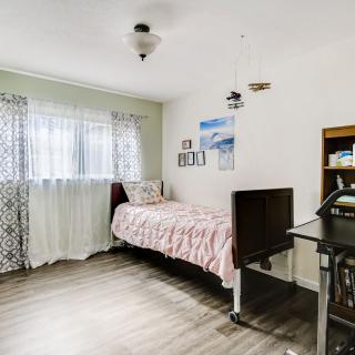 A cozy bedroom with a single bed, desk, and decorative items.