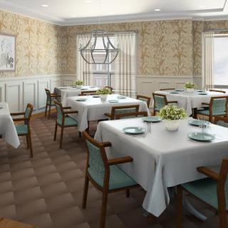 An elegant dining room with neatly arranged tables and chairs, adorned with white tablecloths and soft lighting from a central chandelier.
