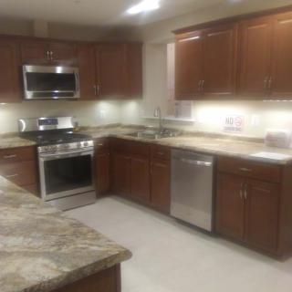 Modern kitchen with stainless steel appliances and wooden cabinets.