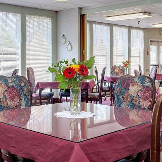 A cozy dining room with a table adorned with a vibrant floral centerpiece.