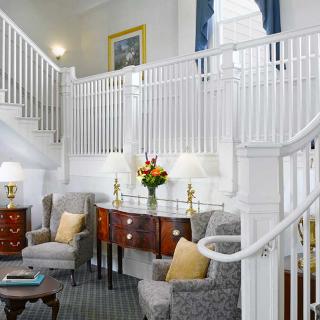 A cozy and elegant seating area with a staircase and tasteful decor.