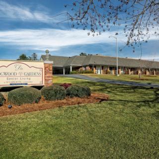 A medical clinic building with a prominent entrance sign, surrounded by landscaped greenery.