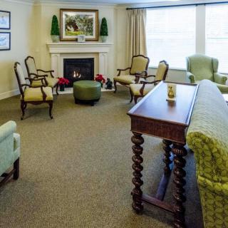 A cozy living room with a fireplace, classic furniture, and warm lighting.