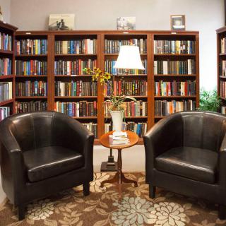 Cozy library nook with leather chairs and bookshelves.