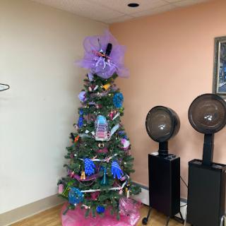 A beautifully decorated Christmas tree adorned with purple and colorful decorations in a cozy indoor setting.