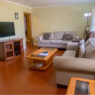 A cozy living room with sofas, a coffee table, and a television.