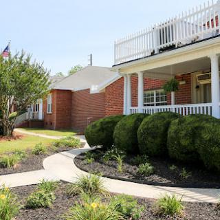 A beautiful residential home with well-maintained landscaping and a welcoming porch.
