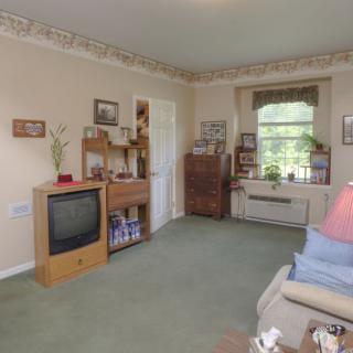 A cozy living room with vintage decor and a large window.
