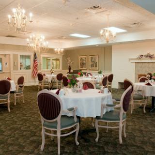 An elegant dining room featuring beautifully set tables and chandeliers.