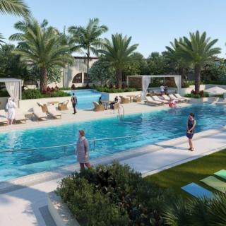 A relaxing outdoor pool area surrounded by palm trees, with people enjoying the sunny weather.