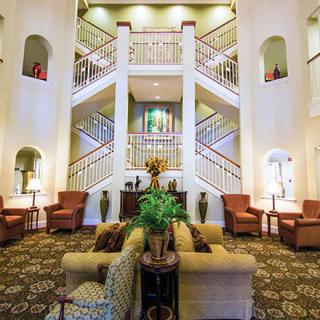 A spacious lobby featuring elegant staircases and comfortable seating arrangements.