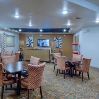 A cozy indoor lounge with arranged seating, a television, and a popcorn machine.