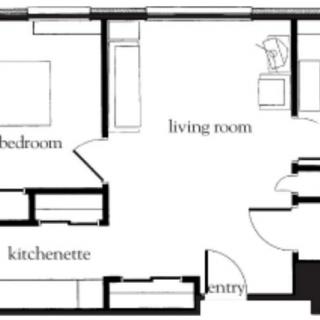 A simple floor plan featuring a bedroom, living room, kitchenette, and entry.