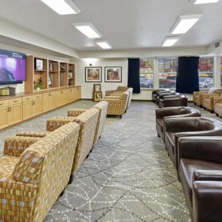A spacious lounge area with comfortable seating and a large television.