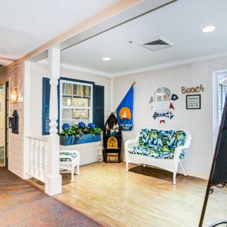 A charming lobby area with a bench decorated in floral patterns and nautical decor.