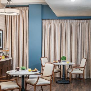 A cozy dining area with elegant curtains and classic wooden furniture.