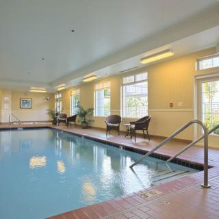 An inviting indoor swimming pool area with seating and large windows.