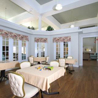 A beautifully designed dining room with tables and chairs, featuring large windows and elegant decor.