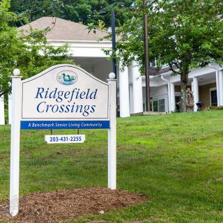 Entrance sign for Ridgefield Crossings surrounded by trees.
