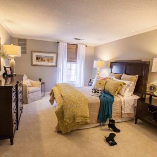A cozy bedroom with elegant furniture and warm lighting.