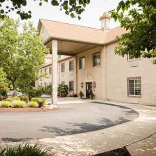The exterior of a welcoming hotel entrance surrounded by lush greenery.