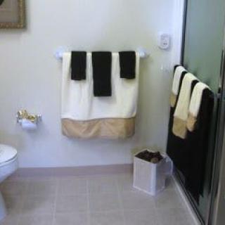 A neatly arranged bathroom with towels and a shower area.