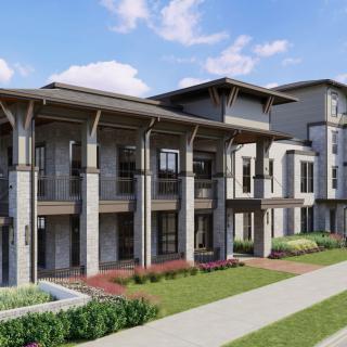 A modern residential apartment building with landscaped surroundings and a clear blue sky.