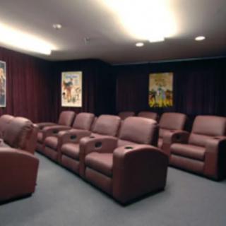 A cozy home theater with rows of comfortable leather armchairs.