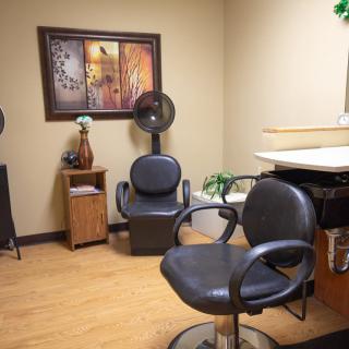 A cozy hair salon with chairs, art on the wall, and stylish decor.