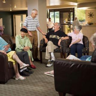 A group of seniors socializing in a community room setting.