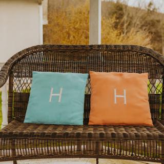 A cozy outdoor setting with colorful cushions on a wicker bench.