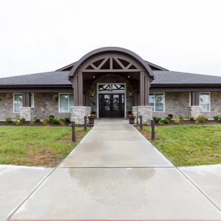 A modern building with an arched entrance and landscaped surroundings.