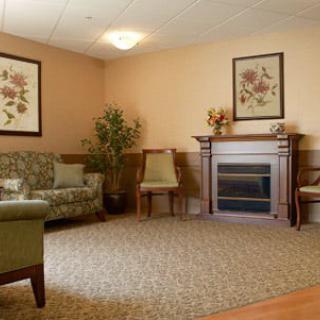 A cozy living room with a fireplace, featuring comfortable seating and tasteful decor.