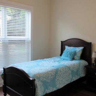 A cozy bedroom with a single bed and a window letting in natural light.