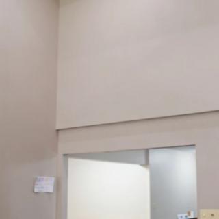 A minimalist interior with beige walls and a door leading to another room.
