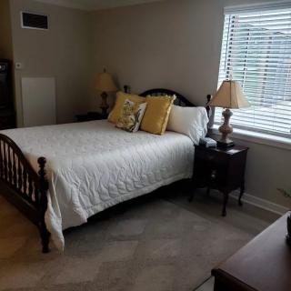 A cozy bedroom with a comfortable bed, nightstands, and soft lighting.