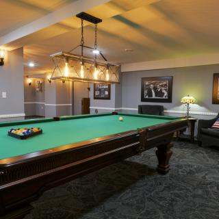 A stylish recreation room featuring a pool table and elegant lighting.