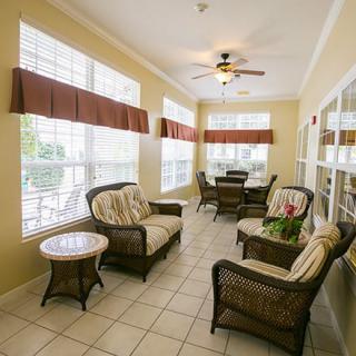 A cozy sunroom with rattan furniture and large windows letting in abundant natural light.