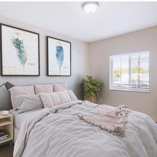 A cozy, minimalist bedroom with simple decor and natural light.