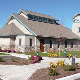 A suburban residential house with well-maintained landscaping and a clear blue sky.