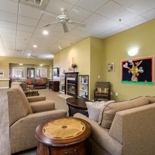 A cozy living room with comfortable seating and colorful artwork on the wall.