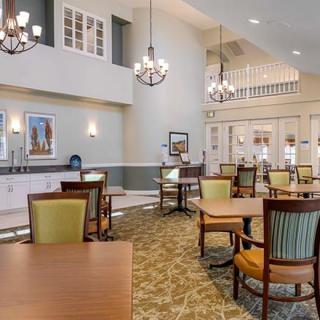 A spacious and elegant dining area with chairs, tables, and chandeliers.