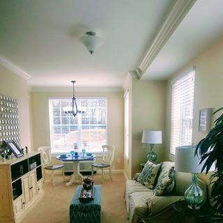 A cozy living and dining space with natural light, featuring a sofa, a dining table, and stylish decor.