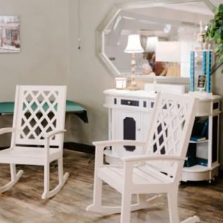 A cozy living room setup featuring two white rocking chairs, a stylish mirror, and elegant home decor.